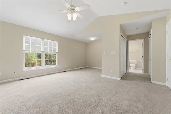 an empty room with a ceiling fan and a window