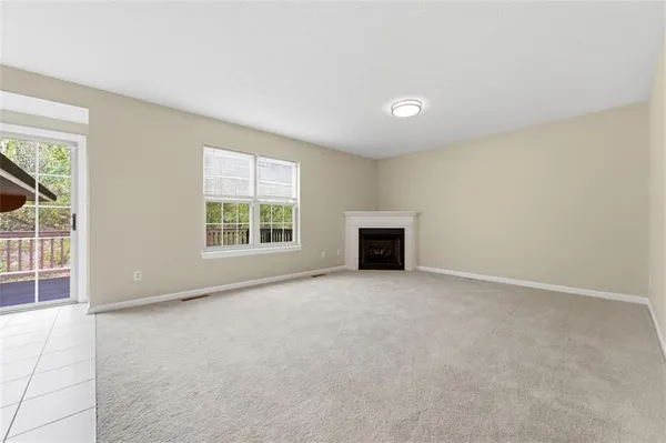 an empty room with windows and fireplace