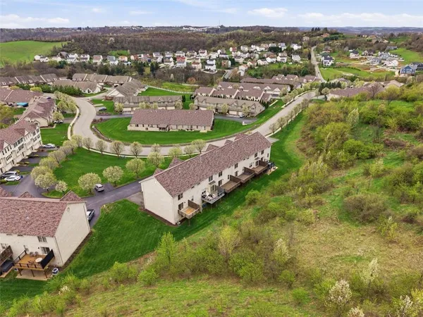 an aerial view of residential houses with outdoor space and trees