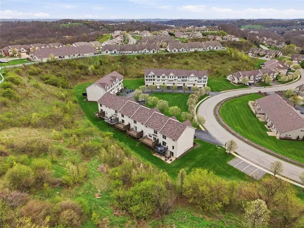 an aerial view of a house with a garden and lake view