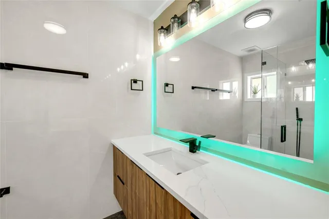 a bathroom with a granite countertop sink and a mirror