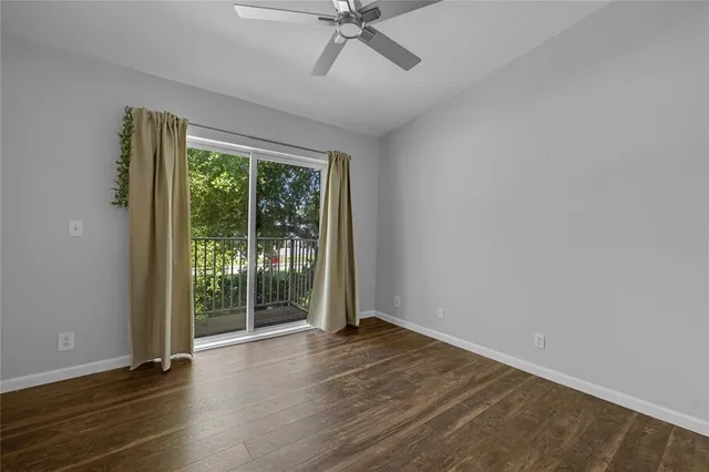 a view of a livingroom with wooden floor and a ceiling fan
