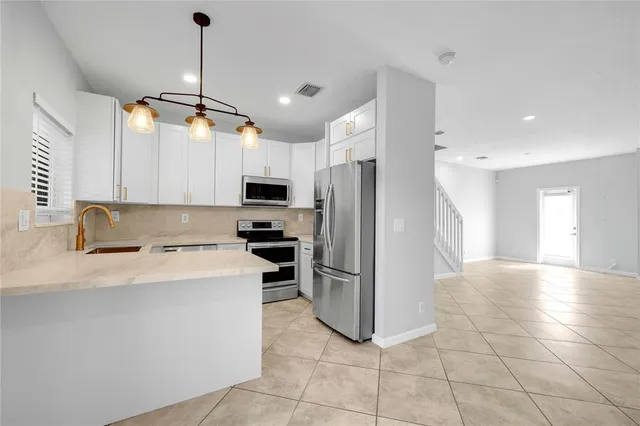 a kitchen with kitchen island a counter top space appliances and cabinets