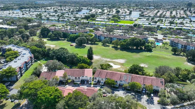 an aerial view of residential houses with outdoor space and swimming pool