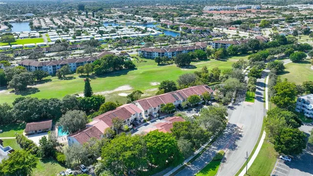 an aerial view of residential houses with outdoor space and lake view