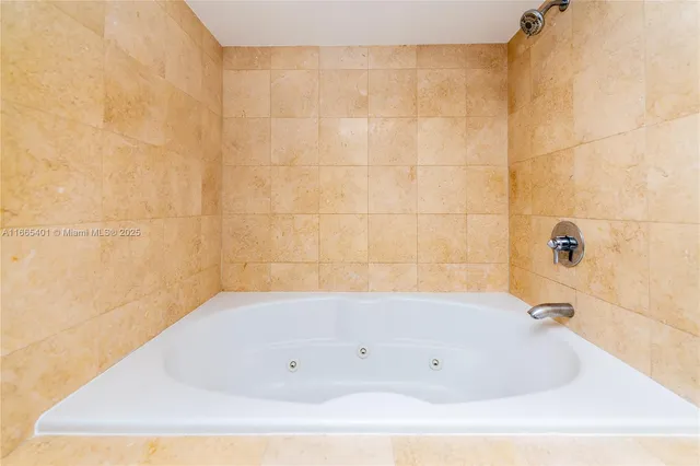 a kitchen with stainless steel appliances kitchen island granite countertop a refrigerator and a sink