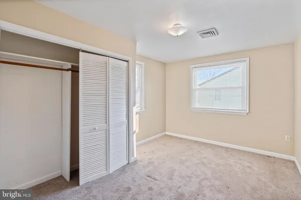 an empty room with windows and closet