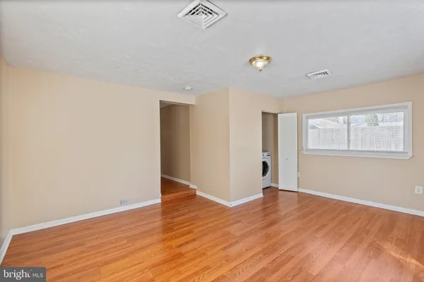 a view of an empty room with wooden floor