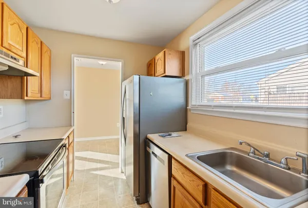 a kitchen with stainless steel appliances granite countertop a sink and a refrigerator