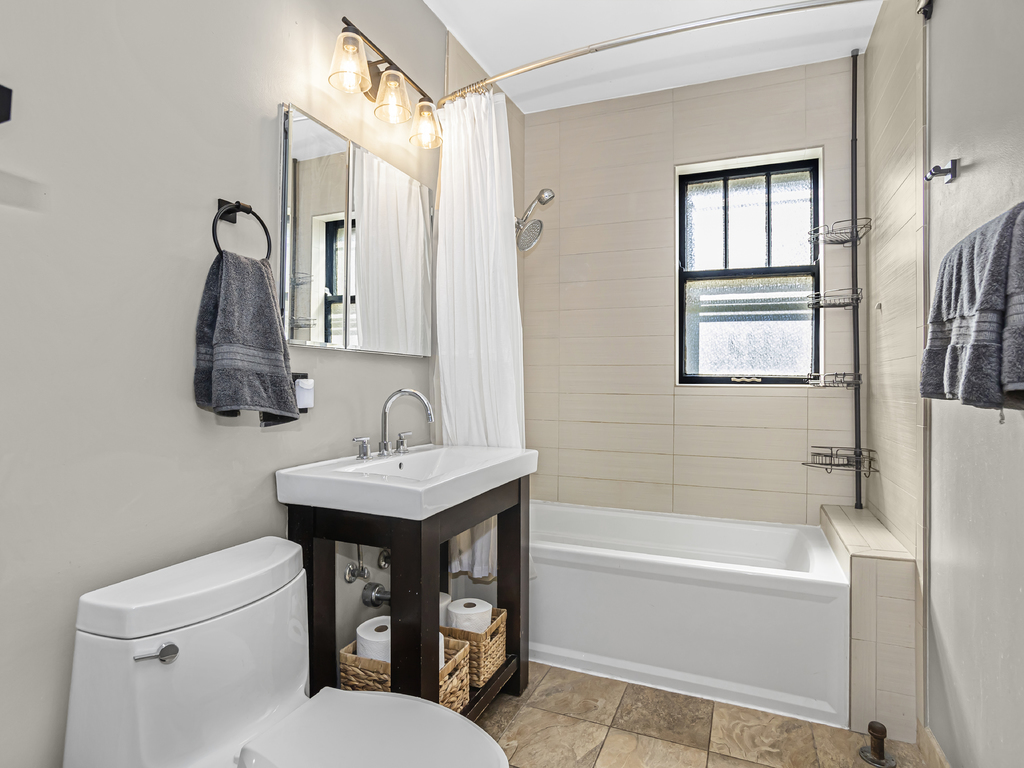 815 Brummel Street, Unit 2 Evanston, IL 60202 - Photo 14 of 16 a bathroom with a toilet sink and mirror