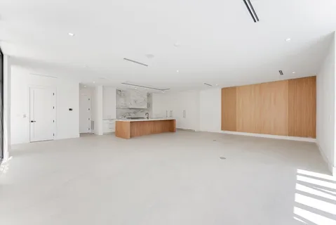 an empty room with wooden floor and mirror