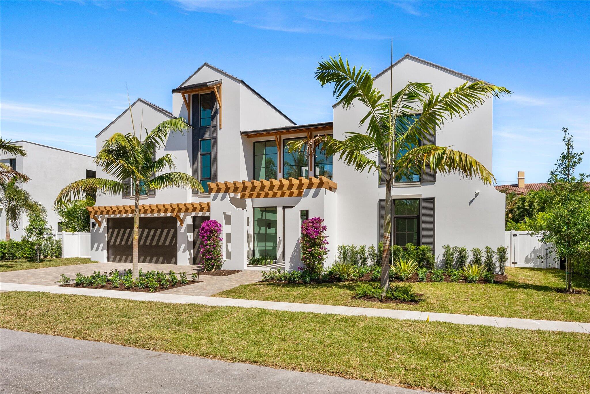 880 Northeast 3rd Avenue Boca Raton, FL 33432 - Photo 5 of 100 a front view of a house with a yard and potted plants