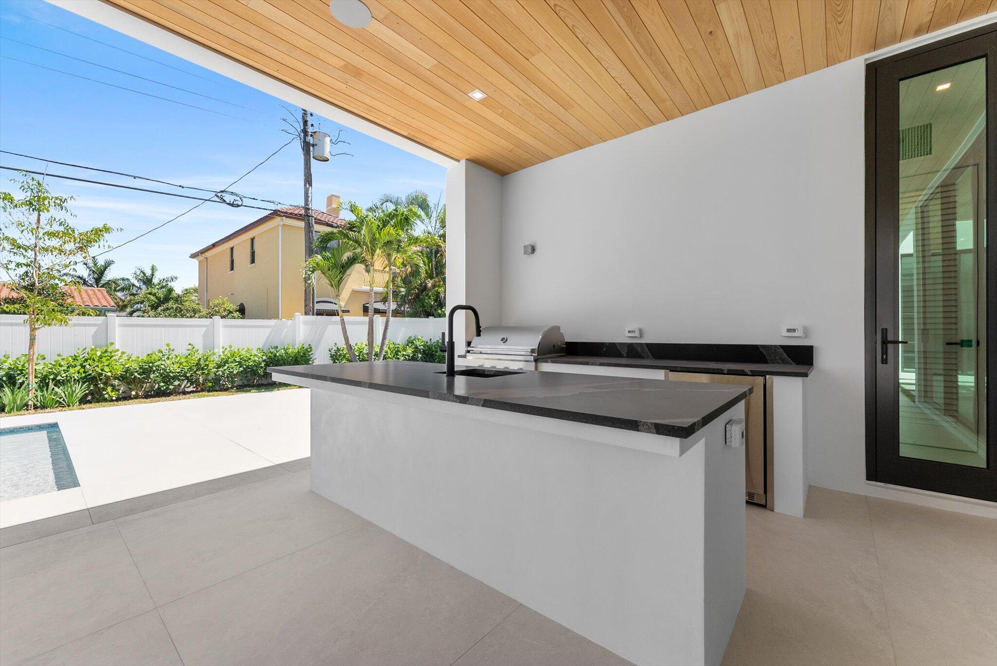 880 Northeast 3rd Avenue Boca Raton, FL 33432 - Photo 81 of 100 a kitchen with kitchen island a sink wooden floor and a large window