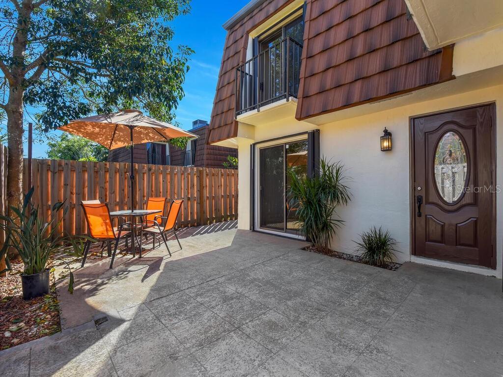 a view of a chairs with an umbrella in front of house