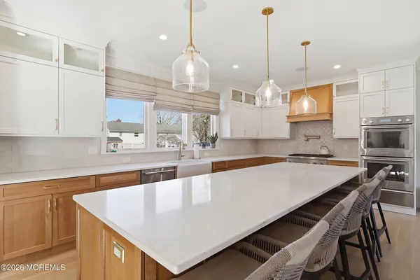 a large kitchen with kitchen island a sink a counter top space and stainless steel appliances