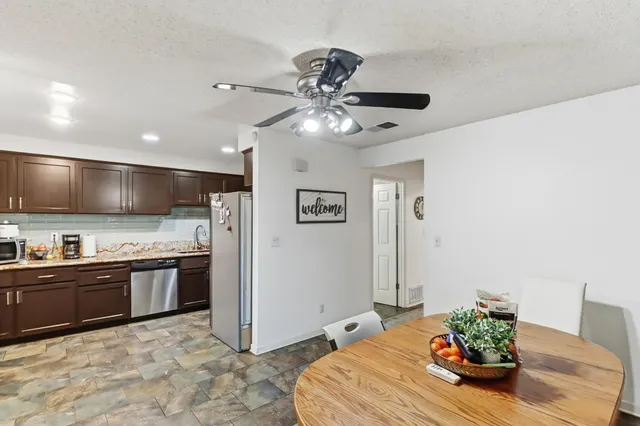 a kitchen with stainless steel appliances granite countertop a refrigerator a stove and a sink