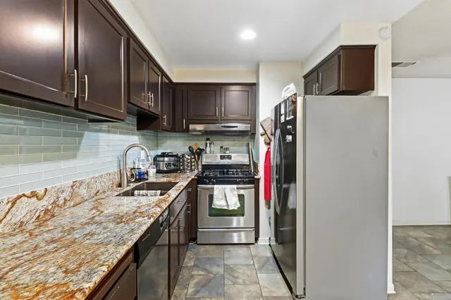 a view of staircase with lots of frames on wall and a dining table