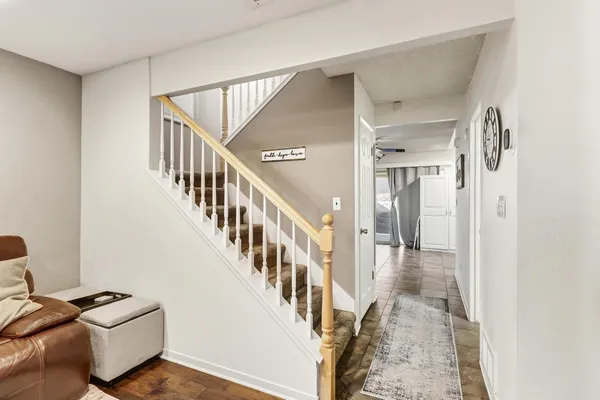 a view of a hallway with wooden floor and a living room