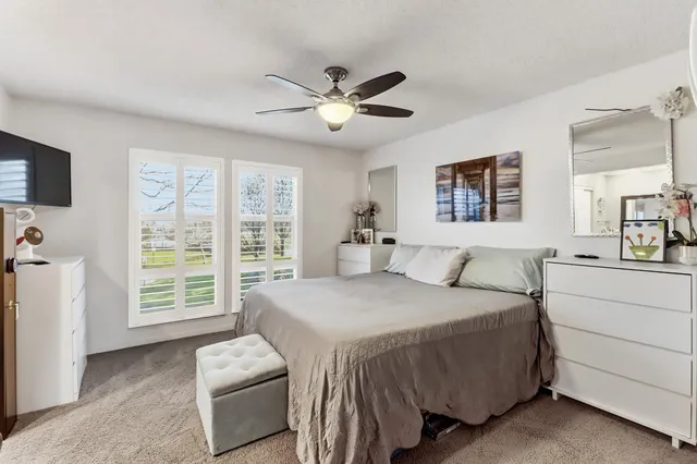 a bedroom with a bed dresser and a flat tv screen