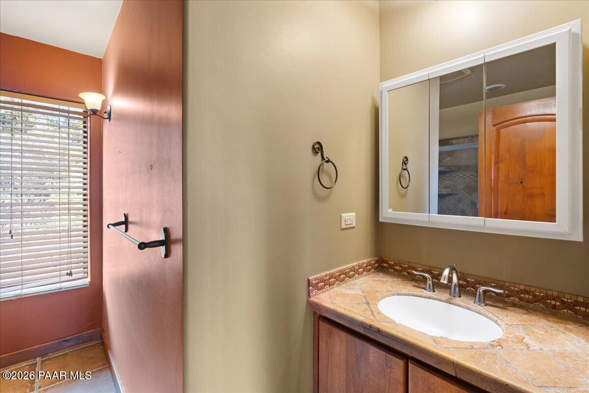 646 South Rancho Vista Drive Prescott, AZ 86303 - Photo 21 of 50 a bathroom with a granite countertop sink a mirror and shower