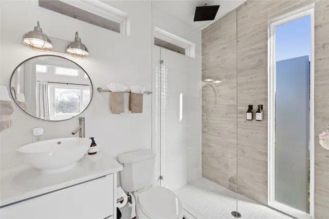 a bathroom with a toilet a sink and a mirror