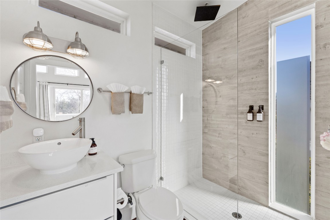 1904 East 17th Street, Unit B Austin, TX 78702 - Photo 25 of 34 a bathroom with a toilet a sink and a mirror