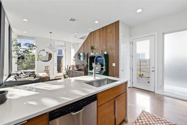 a kitchen with stainless steel appliances granite countertop a sink and a refrigerator