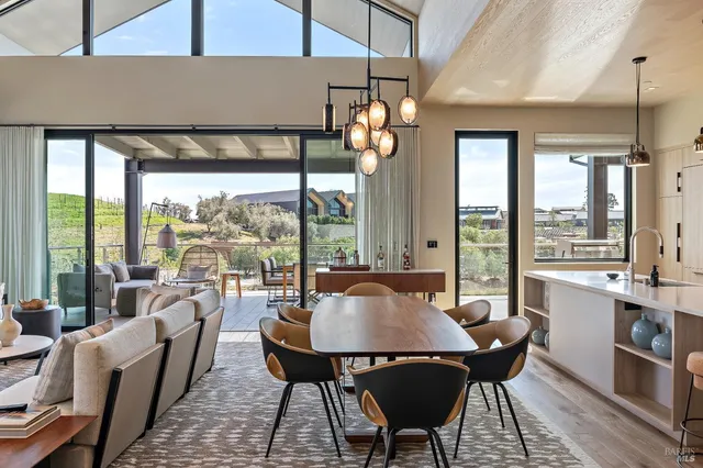 a view of a dining room with furniture large windows and wooden floor