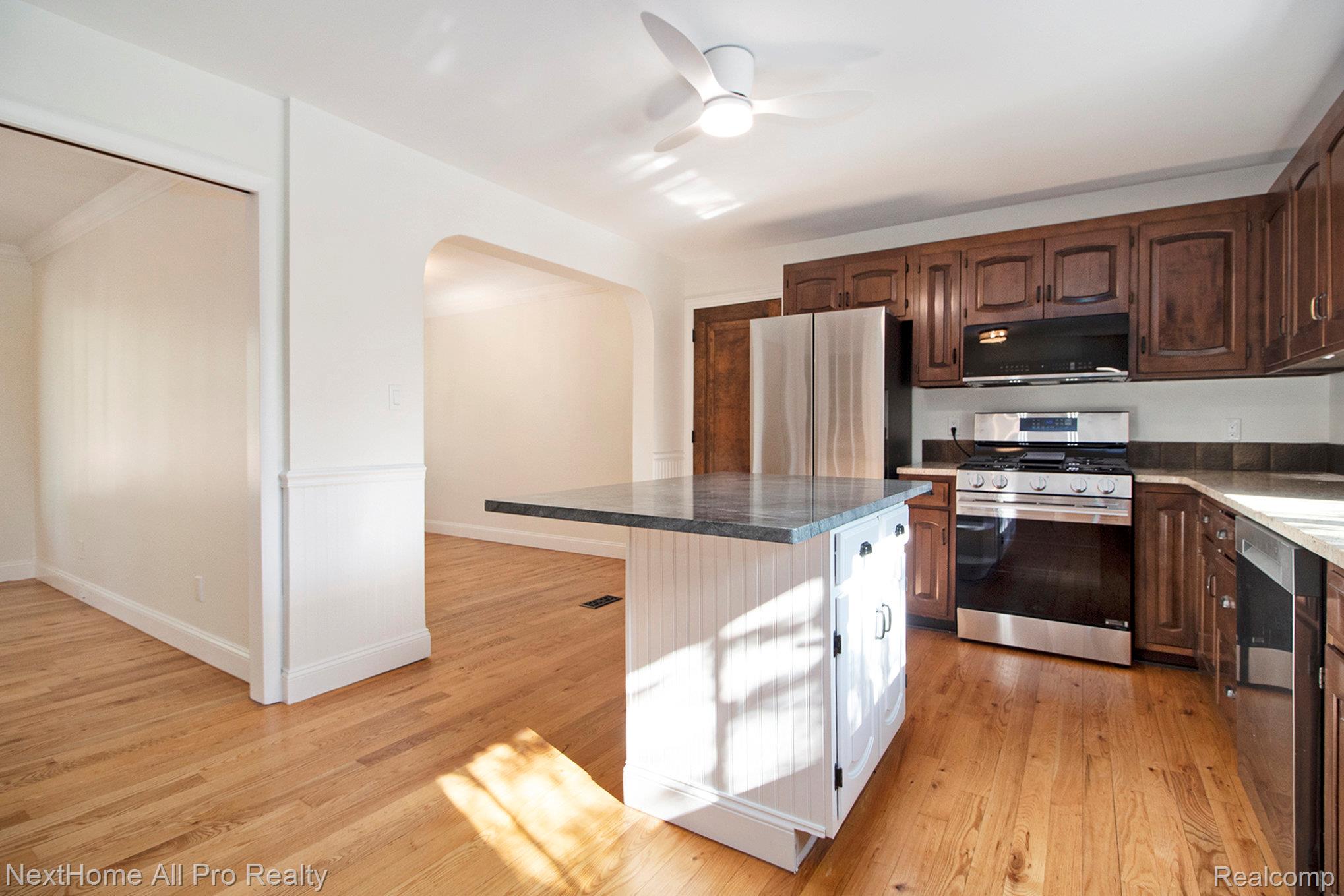 7195 Curtis Road Northville, MI 48168 - Photo 33 of 70 Kitchen featuring stainless steel appliances, quality cabinets with ample storage, kitchen island, and hardwood floors.