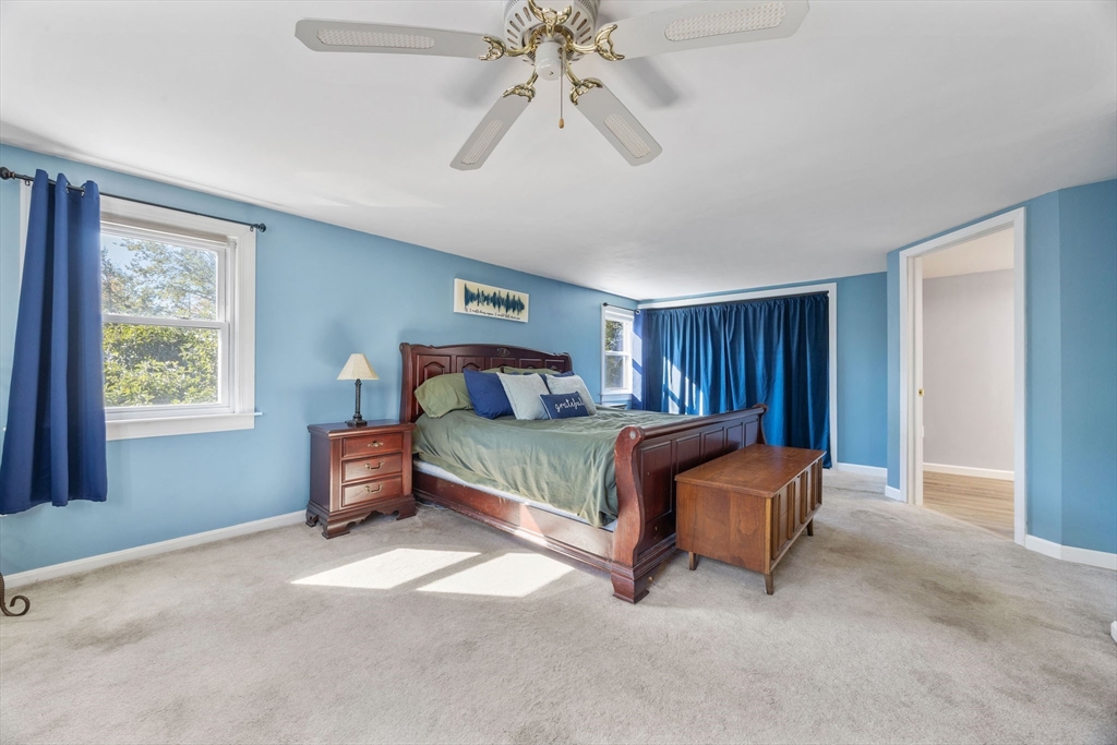229 Washington Terrace Whitman, MA 02382 - Photo 16 of 30 a bedroom with a bed and a chandelier