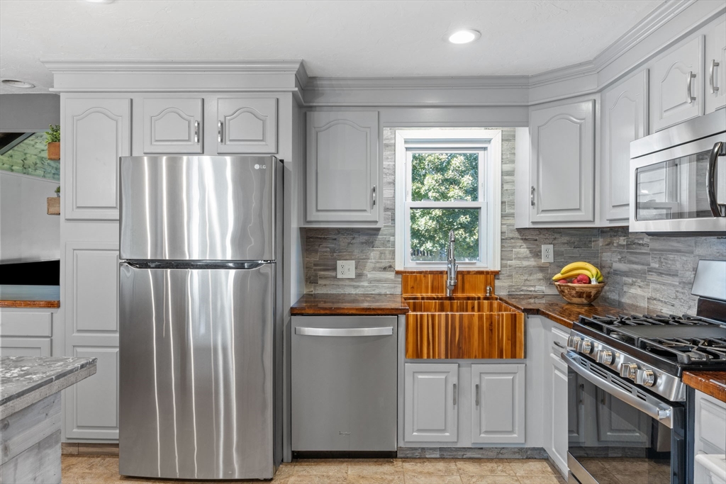 229 Washington Terrace Whitman, MA 02382 - Photo 4 of 30 a kitchen with refrigerator a stove a sink and a window