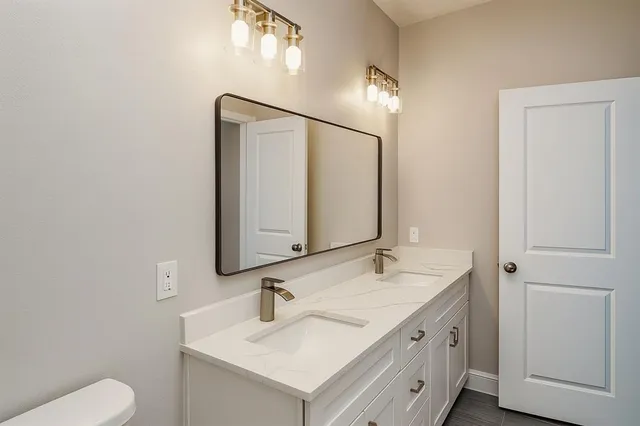a bathroom with a sink toilet and mirror