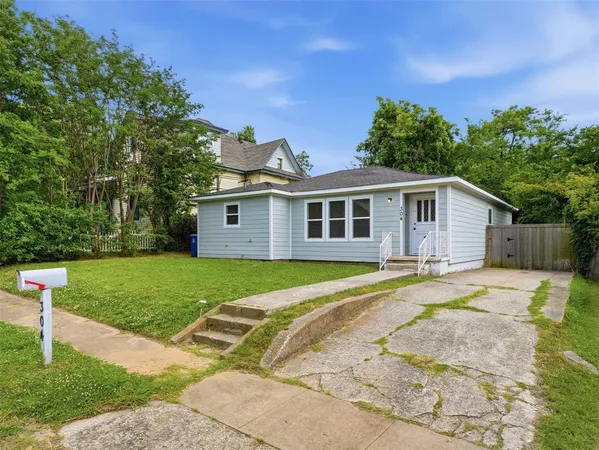 a view of a house with backyard and trees