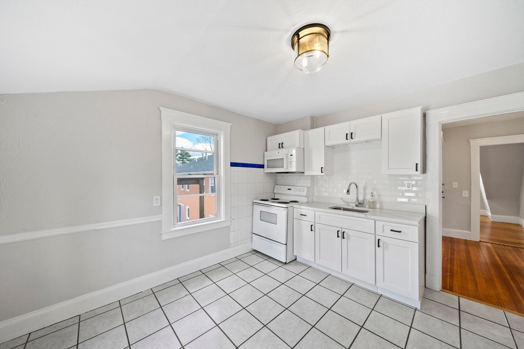 a room with white cabinets and sink