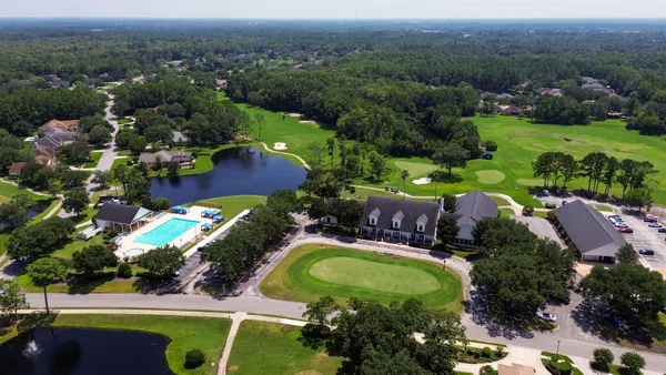 an aerial view of a house with a garden and lake view