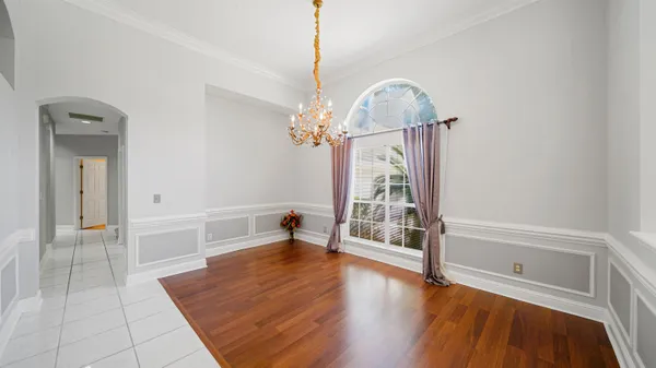 a view of a livingroom with wooden floor and a chandelier