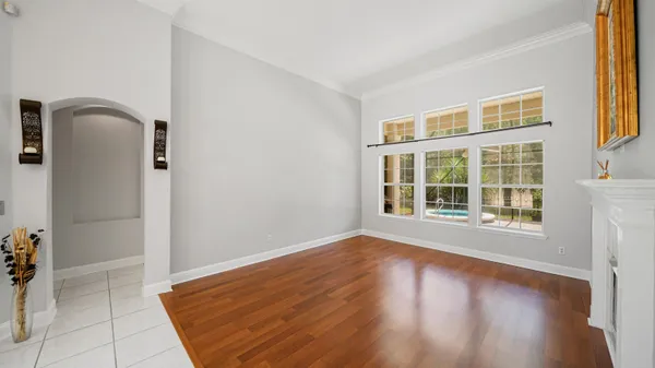 a view of an empty room with glass door and wooden floor