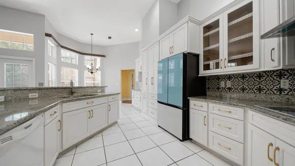a large kitchen with granite countertop a sink and a stove top oven