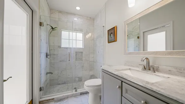 a bathroom with a granite countertop sink toilet and shower