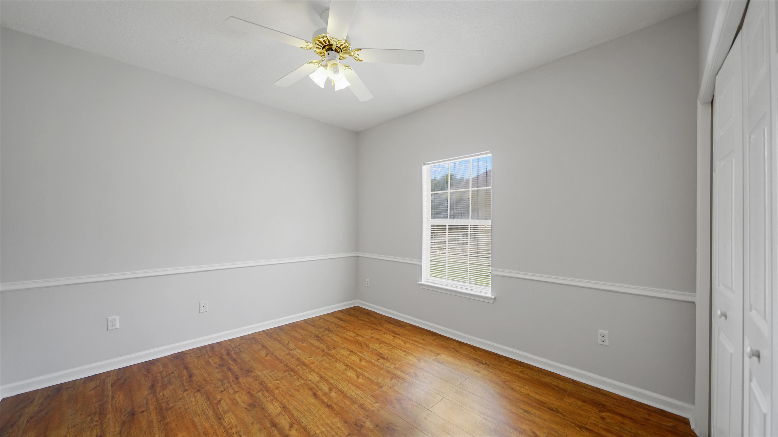 7849 Rittenhouse Lane Jacksonville, FL 32256 - Photo 25 of 50 an empty room with wooden floor fan and windows