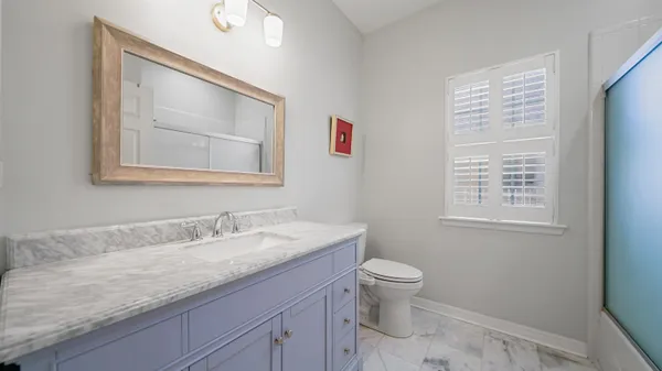 a bathroom with a granite countertop sink a toilet and a mirror