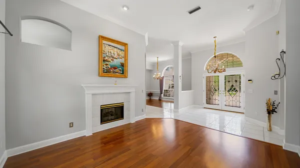 a view of a livingroom with wooden floor a fireplace and windows