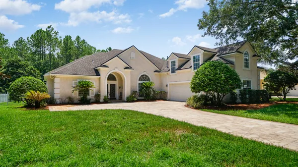 a front view of a house with a garden and plants