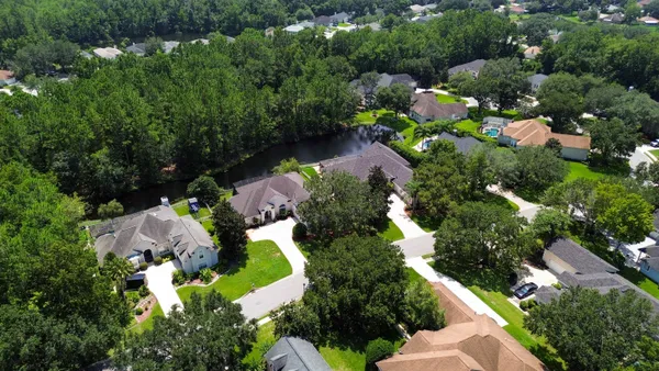 an aerial view of lake houses and trees all around