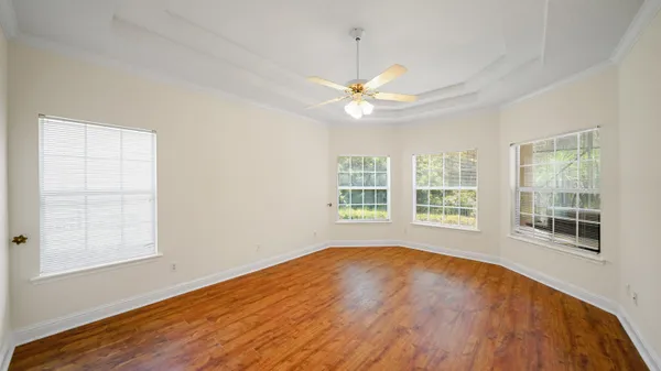 a view of an empty room with a window and wooden floor