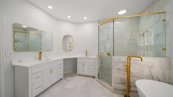 a spacious bathroom with a double vanity sink toilet mirror and shower