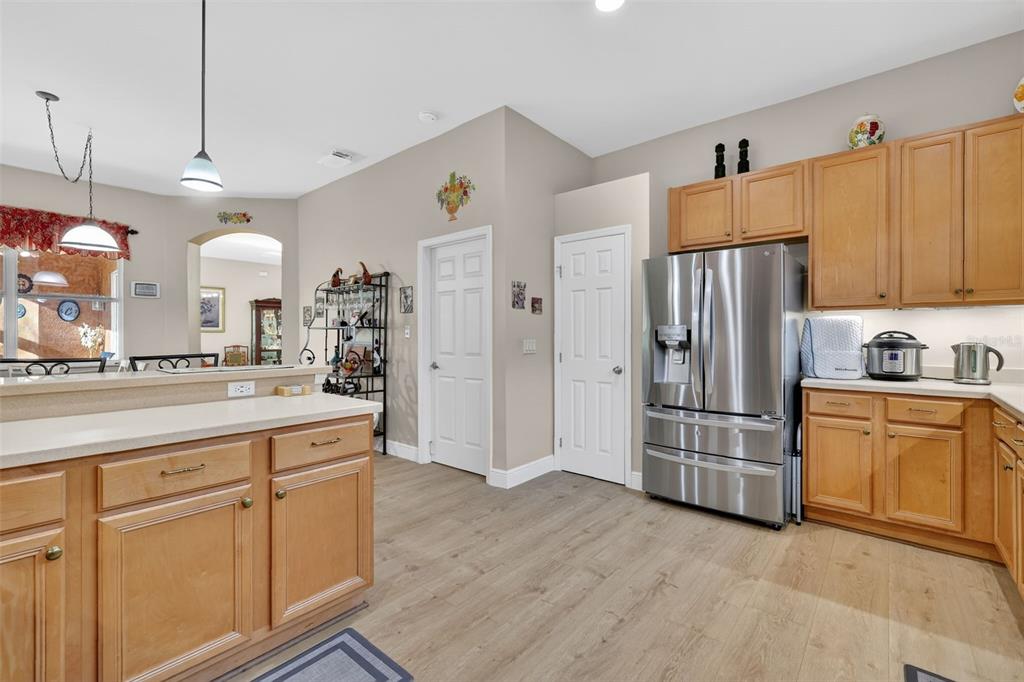 25517 Laurel Valley Road Leesburg, FL 34748 - Photo 16 of 56 a kitchen with kitchen island white cabinets and refrigerator