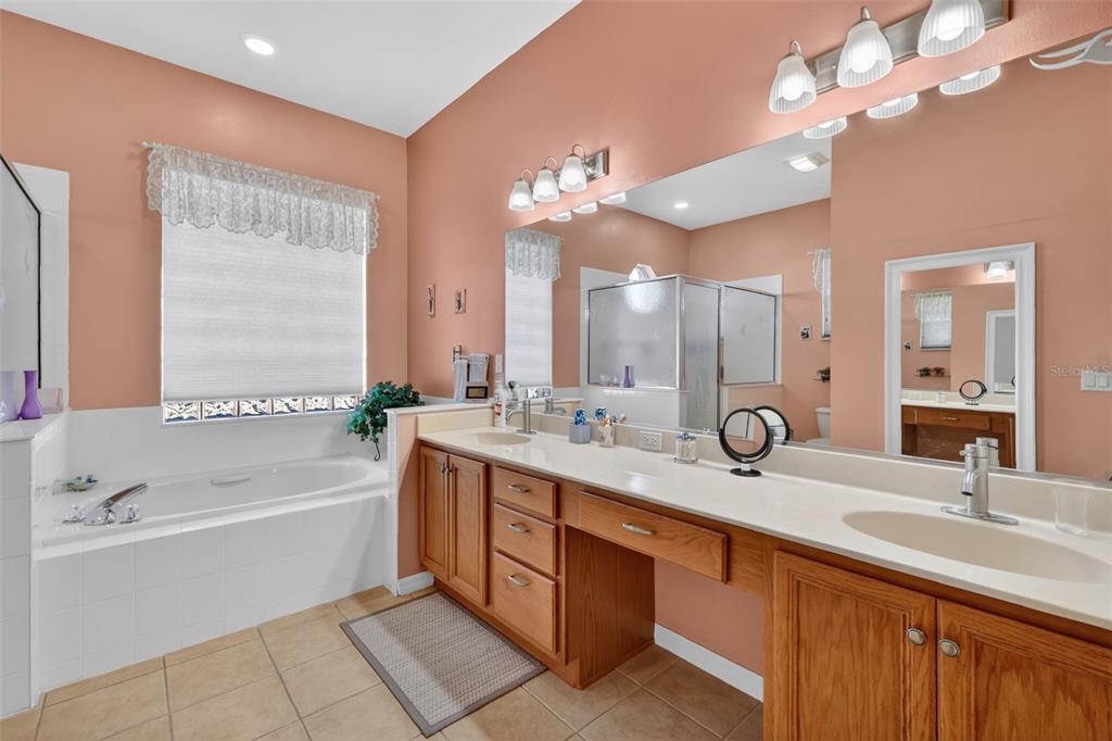 25517 Laurel Valley Road Leesburg, FL 34748 - Photo 27 of 56 a bathroom with a tub a sink double vanity and a mirror