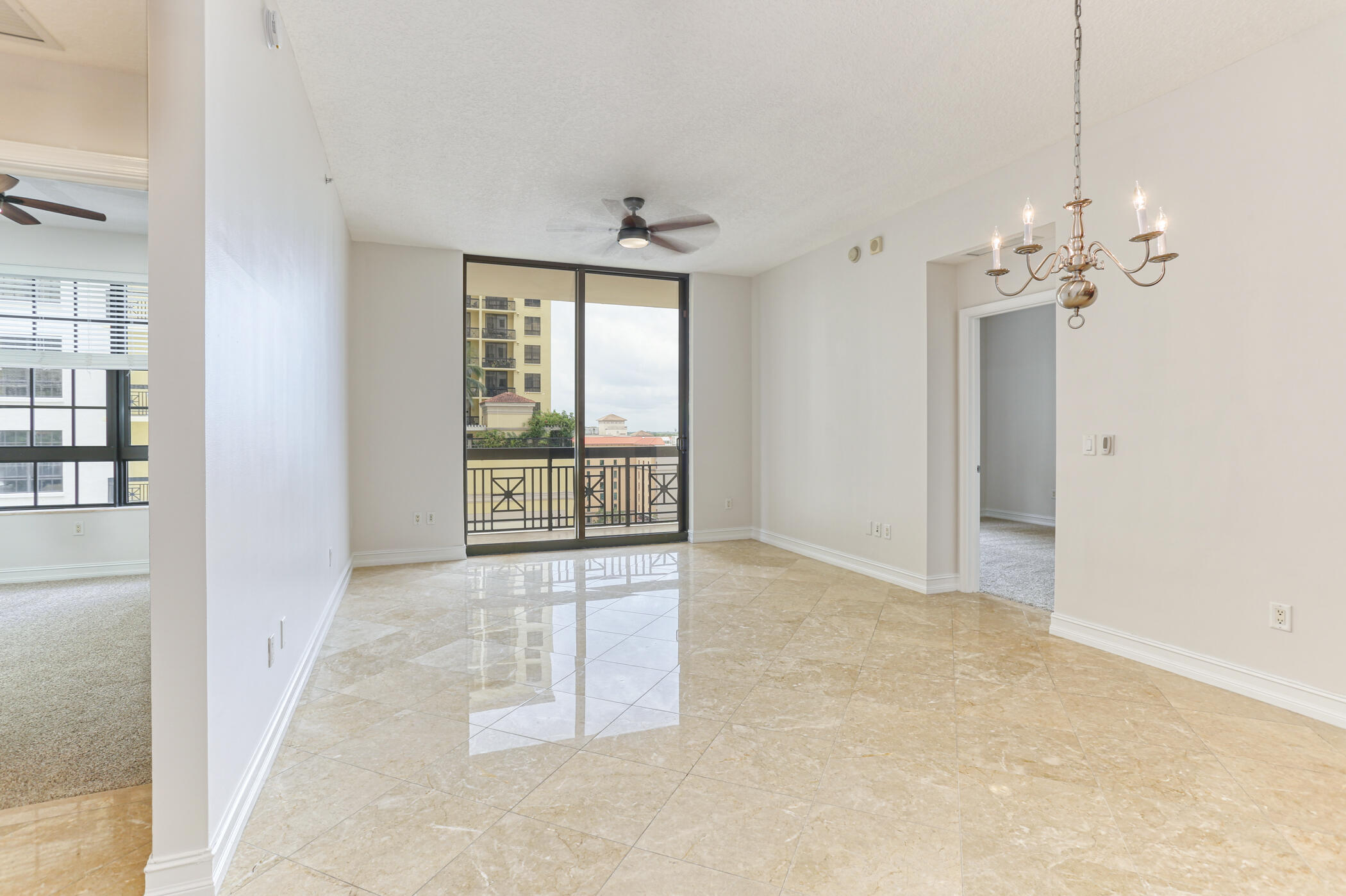 701 South Olive Avenue, Unit 603 West Palm Beach, FL 33401 - Photo 1 of 23 an empty room with chandelier and windows