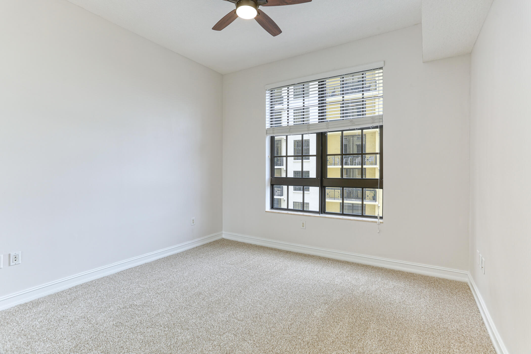 701 South Olive Avenue, Unit 603 West Palm Beach, FL 33401 - Photo 13 of 23 an empty room with chandelier fan and windows